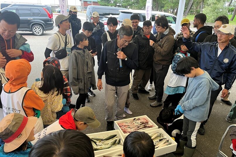 Participants receiving an explanation from Fisheries Cooperative members about the fish caught at Teradomari Port